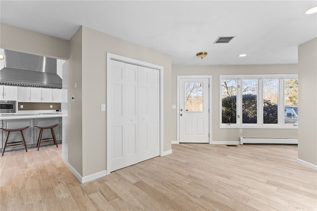 entrance foyer featuring plenty of natural light, light wood-style floors, and baseboard heating