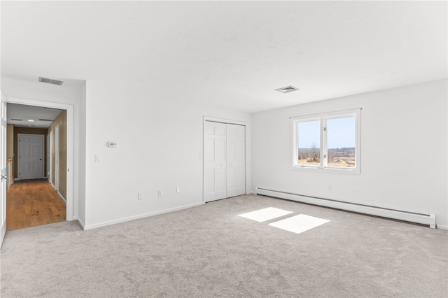 unfurnished bedroom featuring a closet, visible vents, carpet floors, and a baseboard radiator