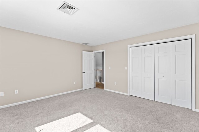 unfurnished bedroom with a closet, visible vents, baseboards, and carpet