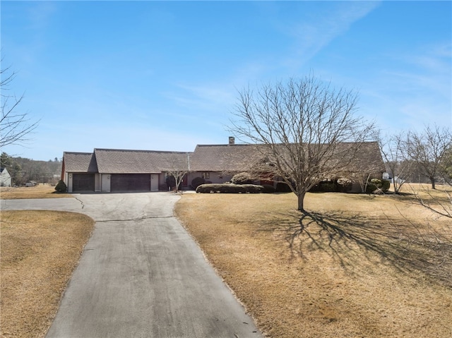 view of front of home featuring a front lawn, a garage, and driveway