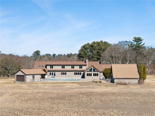 view of front of house featuring an outdoor structure and fence