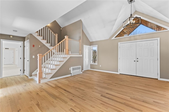 entryway featuring a chandelier, wood finished floors, and stairs