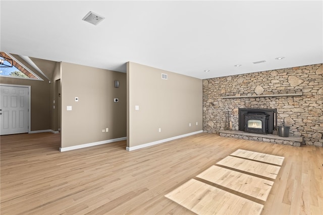 unfurnished living room featuring visible vents, baseboards, light wood-style floors, and vaulted ceiling