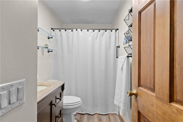 full bathroom featuring a shower with curtain, toilet, wood finished floors, and vanity