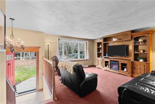 carpeted living room featuring a notable chandelier, baseboards, and a textured ceiling