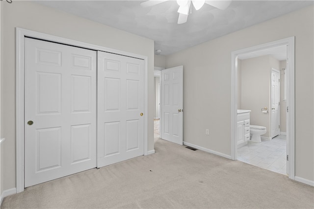 unfurnished bedroom with baseboards, carpet, a closet, and connected bathroom