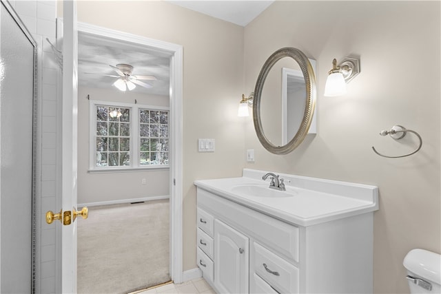 bathroom featuring baseboards, toilet, vanity, and a ceiling fan