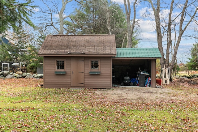 view of outdoor structure with a carport and an outbuilding