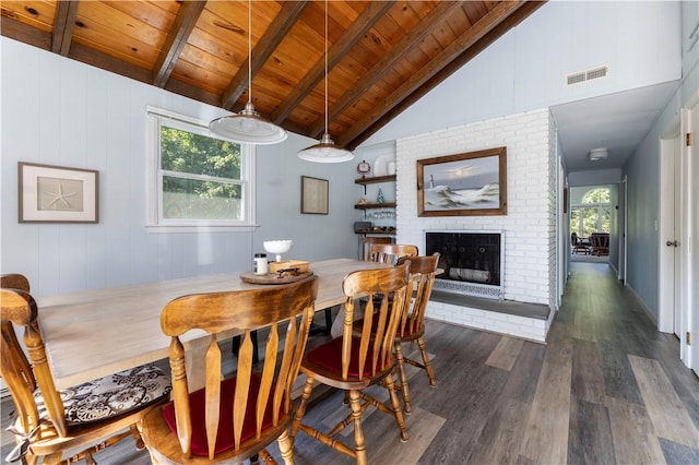 dining area featuring wooden ceiling, a brick fireplace, a healthy amount of sunlight, and lofted ceiling with beams