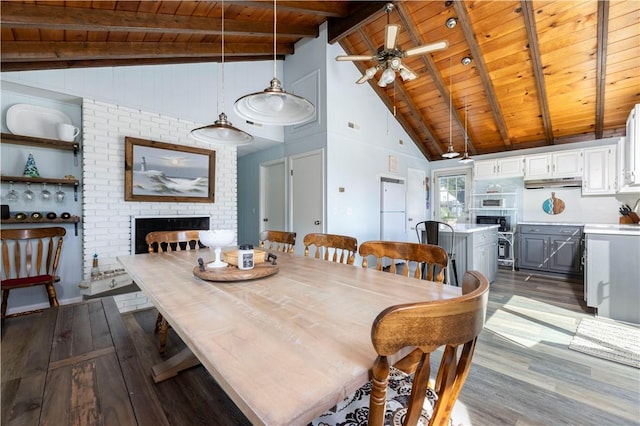 dining area with beam ceiling, wood ceiling, a fireplace, and dark wood-style flooring