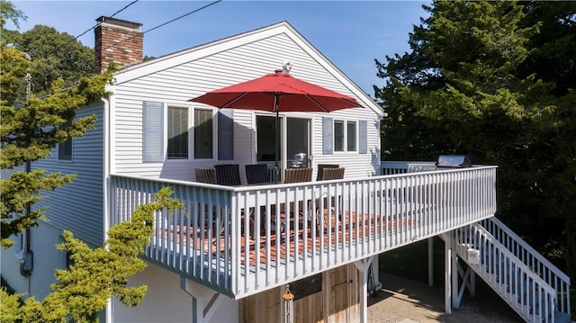 exterior space with stairs, a deck, and a chimney