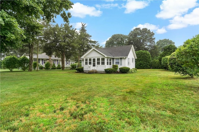 exterior space featuring a yard and a sunroom