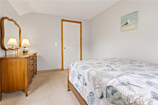 bedroom featuring light colored carpet and vaulted ceiling