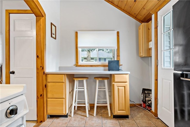 laundry room with cabinet space, wood ceiling, and light tile patterned flooring