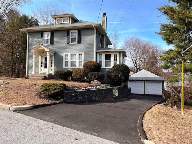 american foursquare style home with an outbuilding, a chimney, and a garage