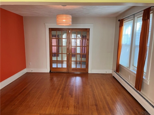 empty room with hardwood / wood-style flooring, french doors, baseboards, and baseboard heating