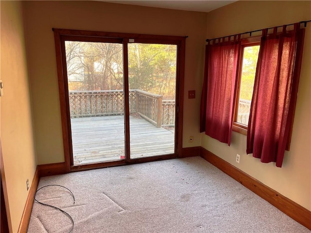 carpeted spare room with a wealth of natural light and baseboards