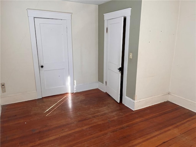 unfurnished room with hardwood / wood-style flooring and baseboards