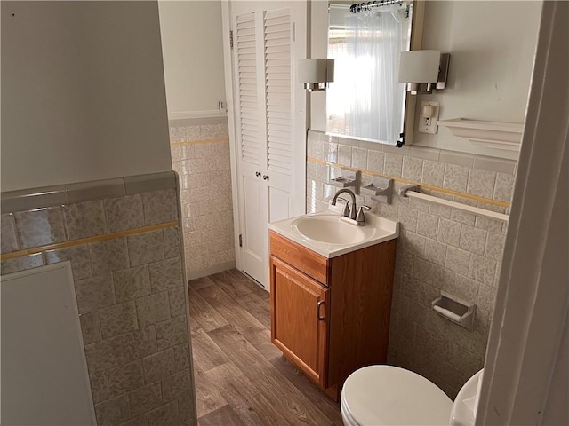 bathroom with vanity, tile walls, toilet, and wood finished floors