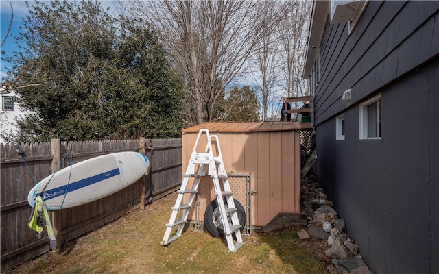 view of yard featuring an outbuilding, a fenced backyard, and a shed