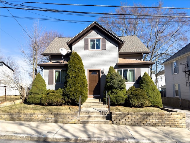 view of front of home featuring roof with shingles and fence