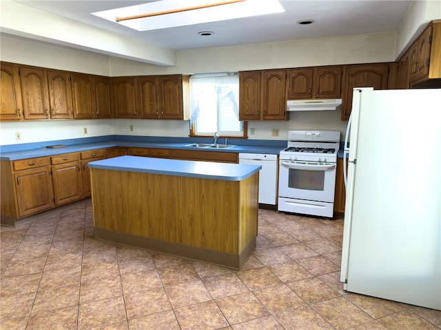 kitchen with a kitchen island, under cabinet range hood, a skylight, white appliances, and a sink