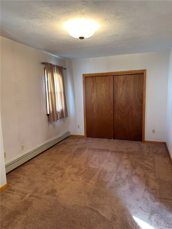 unfurnished bedroom featuring a textured ceiling, a closet, baseboard heating, and light carpet