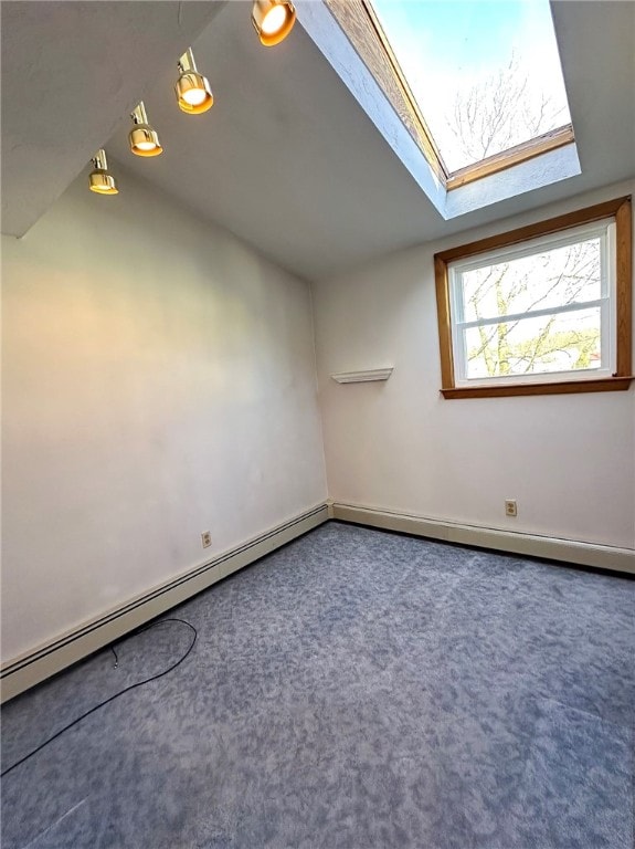 additional living space with lofted ceiling with skylight, a baseboard heating unit, and carpet floors