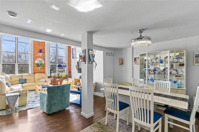 dining room with baseboards, a notable chandelier, and wood finished floors