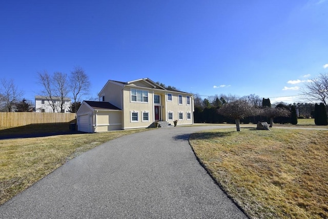 view of front of house featuring aphalt driveway, an attached garage, fence, and stucco siding