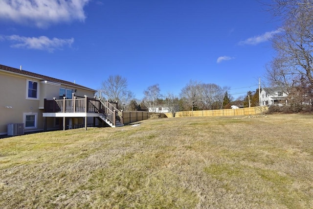 view of yard with stairs, a deck, central air condition unit, and fence