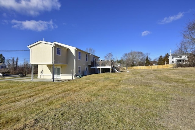 view of yard with a patio, a deck, stairs, and fence