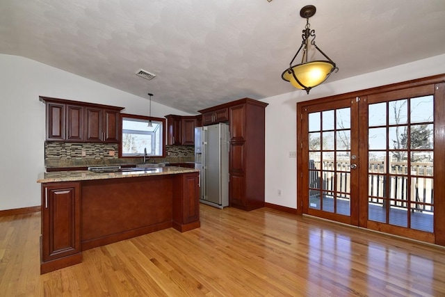 kitchen with light wood finished floors, visible vents, lofted ceiling, french doors, and white fridge with ice dispenser