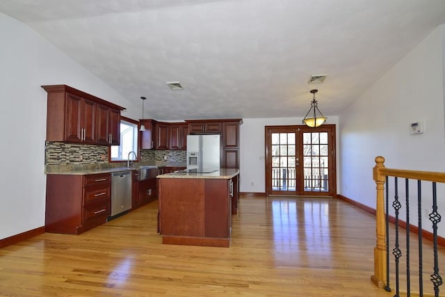 kitchen with tasteful backsplash, french doors, light wood-style floors, white fridge with ice dispenser, and stainless steel dishwasher