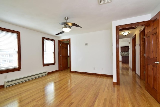 unfurnished room with a ceiling fan, visible vents, baseboards, a baseboard heating unit, and light wood-type flooring