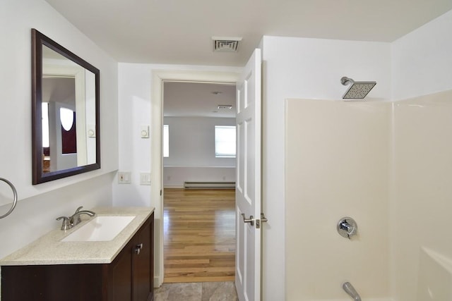 bathroom with vanity, wood finished floors, visible vents, shower / bathing tub combination, and baseboard heating