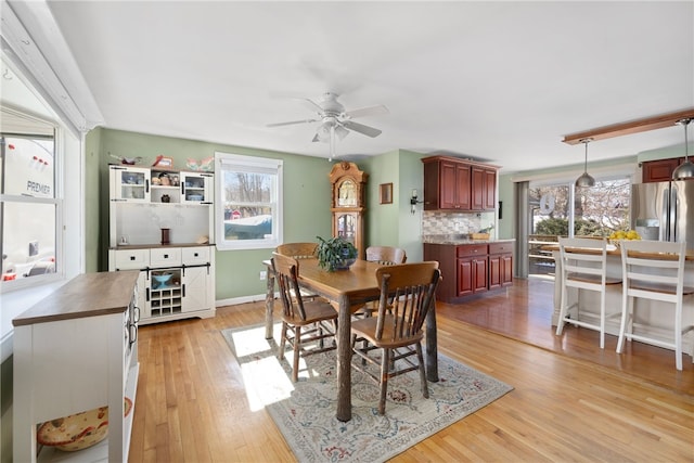 dining room featuring baseboards, light wood-type flooring, and ceiling fan