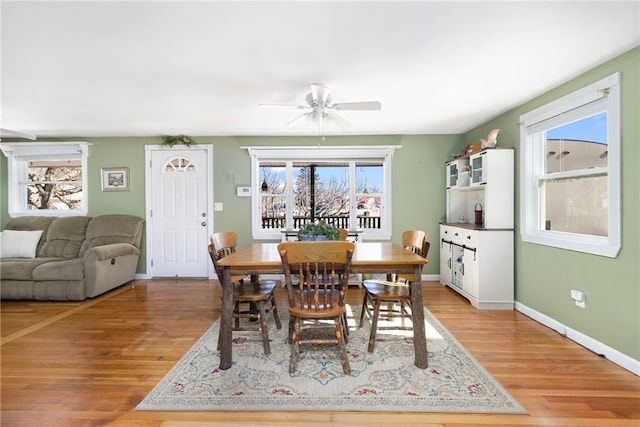 dining room featuring baseboards, light wood-style floors, and a ceiling fan