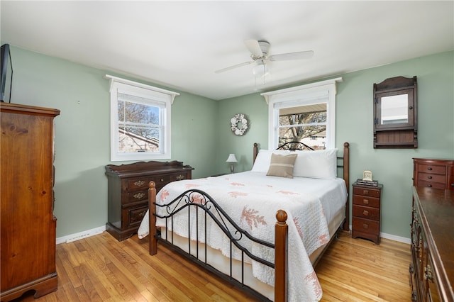 bedroom featuring a ceiling fan, baseboards, and light wood finished floors