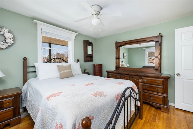 bedroom with a ceiling fan, multiple windows, and wood finished floors