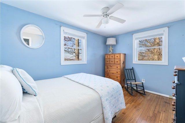 bedroom with baseboards, wood-type flooring, and a ceiling fan