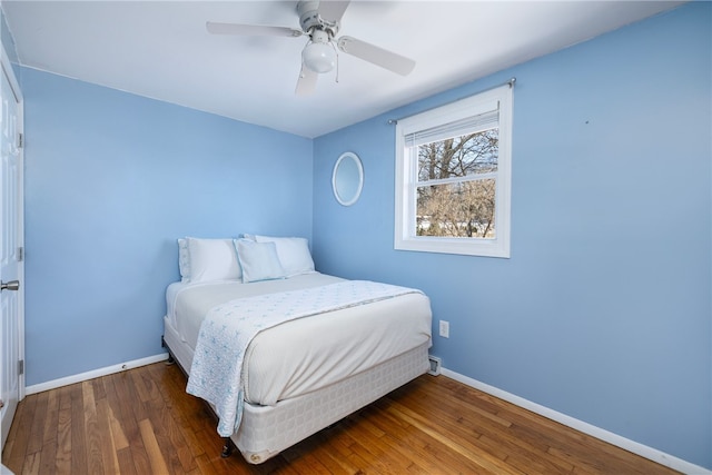 bedroom with baseboards, wood-type flooring, and ceiling fan