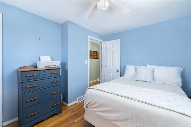 bedroom with light wood-type flooring, baseboards, visible vents, and a ceiling fan