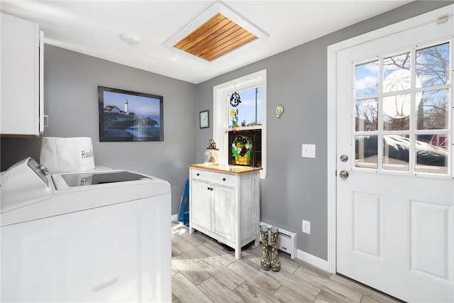 washroom with washer and clothes dryer, cabinet space, baseboards, and wood tiled floor