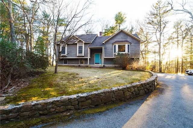 split foyer home with a front lawn and a chimney