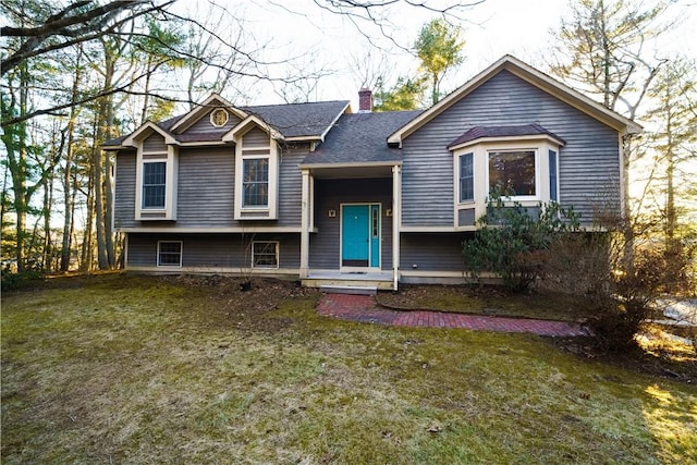 bi-level home with a front lawn, a chimney, and a shingled roof