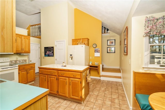 kitchen with white appliances, tile countertops, baseboards, a kitchen island, and light tile patterned flooring