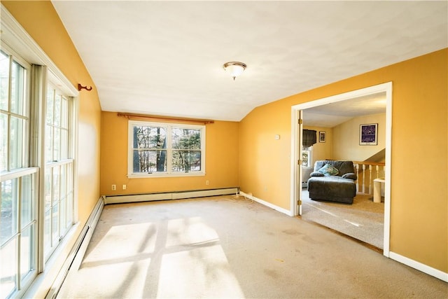 spare room with a baseboard radiator, lofted ceiling, plenty of natural light, and carpet floors