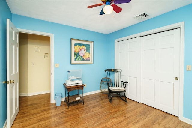 sitting room with visible vents, a ceiling fan, light wood-type flooring, and baseboards