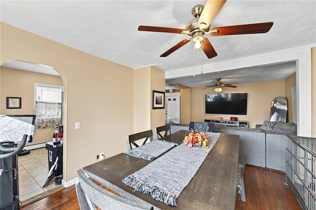 dining area featuring arched walkways and dark wood finished floors